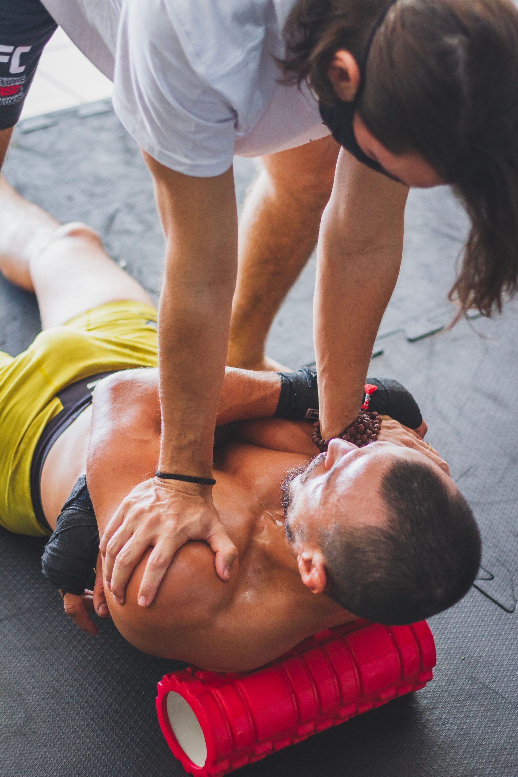 Trainer guiding an athlete through foam rolling